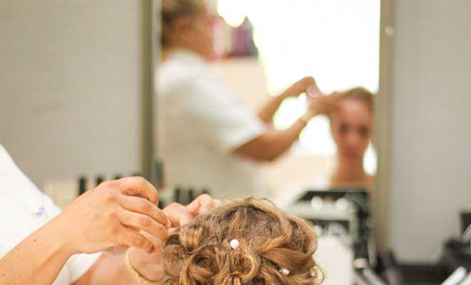 Una novia arreglando su cabello en Nik Salon para su día de boda.